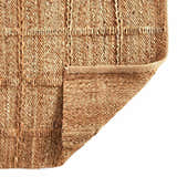 Close-up of Four Hands Grid Jute Rug showing natural jute fibers in a woven grid pattern and folded corner. Fold