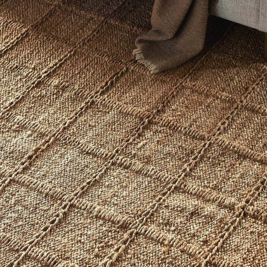 Close-up of the Four Hands Grid Jute Rug, a hand-woven natural fiber rug with a textured grid pattern. Styleshot