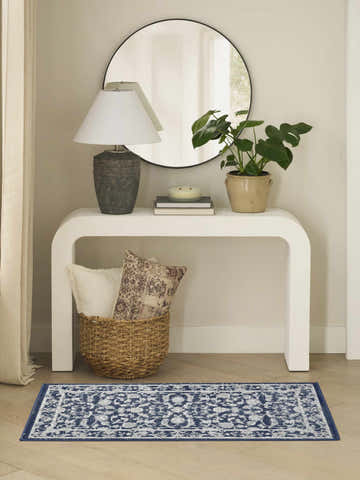 Entryway with white console table, mirror, and Nourison Dekor Slate/Ivory Vintage rug in blue floral pattern on wood floor.