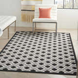 Modern living room with white furniture and Nourison Aloha Black White Area Rug featuring a geometric diamond pattern.