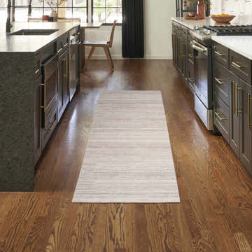 Modern kitchen with Nourison Essentials Ivory Mocha rug runner between dark cabinets and wood floors.