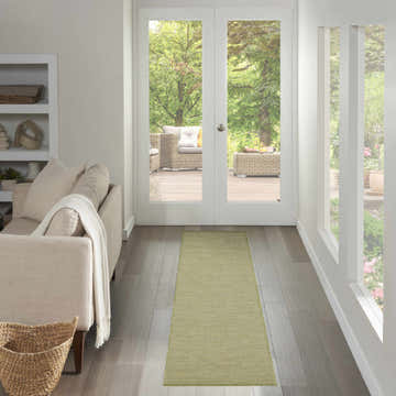 Hallway with a Nourison Positano Green Modern Area Rug runner, leading to patio doors and outdoor seating.