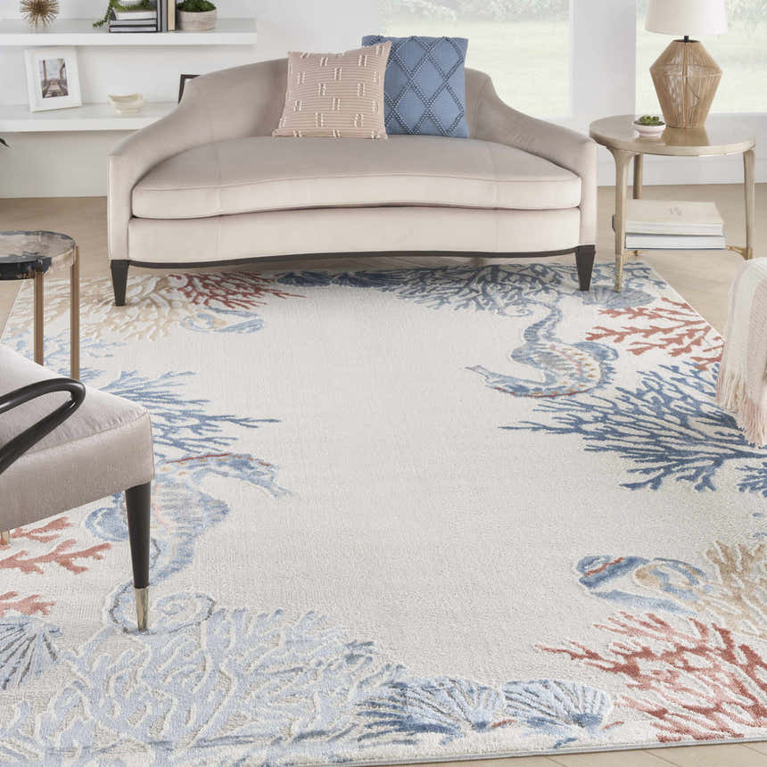 Living room scene with a Nourison Seaside Ivory Multicolor rug featuring coral and seahorse designs.