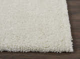 Close-up of the ivory Nourison Malibu Shag rug, showing its plush texture and soft color on a dark wood floor.