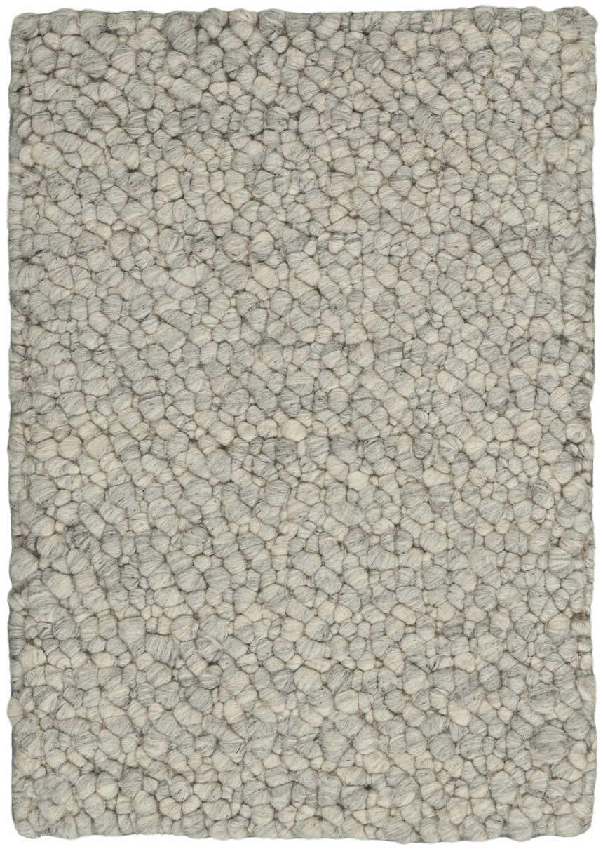 Close-up of the Calvin Klein Riverstone rug. Grey and ivory wool with a textured, pebble-like design. Handmade.