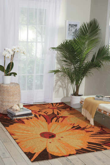 Living room scene with a Nourison South Beach Multicolor Area Rug featuring a large floral design in orange, red, and brown tones.