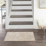 Entryway with Nourison Harmony Ivory rug, dark wood floors, white stairs, and modern bench.