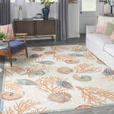 Coastal living room with Waverly Sun N' Shade Ivory Multicolor rug, featuring coral and seashell patterns.
