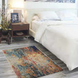 Modern bedroom scene with a Nourison Celestial Multicolor Area Rug, white bedding, and wood nightstand.