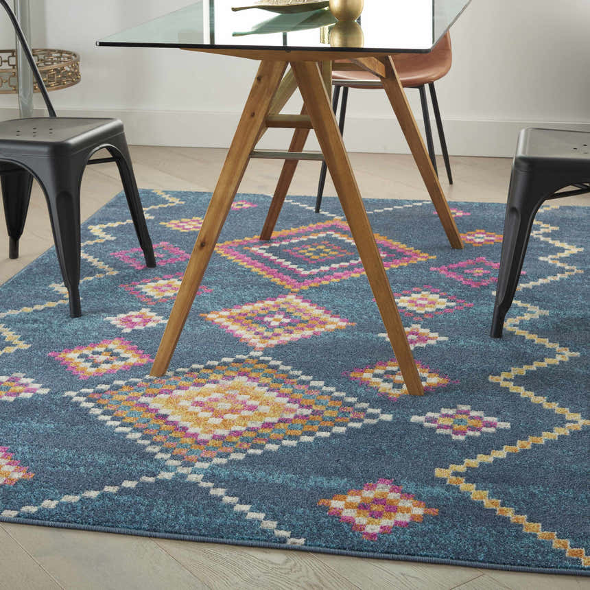 Dining room with a Nourison Passion Navy Bohemian rug featuring geometric pink, yellow, and white patterns.