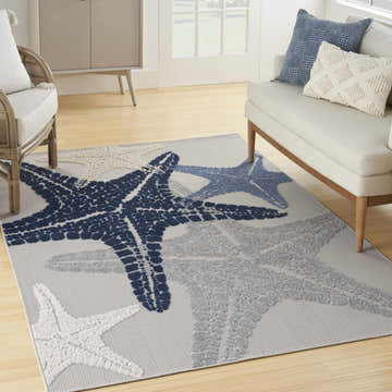 Coastal living room with gray Nourison Aloha rug featuring blue and white starfish.
