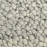 Close-up of the Calvin Klein Riverstone rug showing its grey and ivory wool pebble texture.