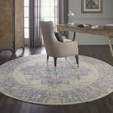 Home office with Nourison Grafix Ivory Pink Vintage Indoor Area Rug, round shape, under a chair and desk.