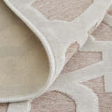 Close-up of Feizy Saphir Mira rug. Pink and white interlocking geometric diamond pattern, showing texture and backing. Fold