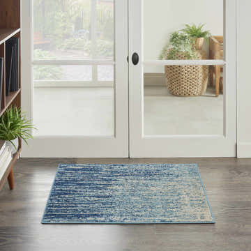 Entryway with a Nourison Passion Navy Light Blue rug, wood floors, and white french doors.