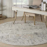 Light-filled office with round Nourison Lynx Ivory Taupe vintage rug under a gold desk and chair. Neutral, calming decor.