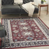 Living room scene with a Nourison Fulton Red Vintage rug, black sofa, and wood side table.