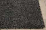 Close-up of the plush texture of the Nourison Malibu Dark Grey Shag Rug on a light wood floor.