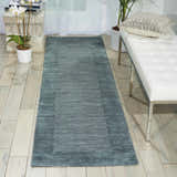 Entryway with Barclay Butera Ripple Spa runner rug, white bench, wood floors, and natural light.