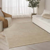 Neutral living room featuring a DKNY Pure Patterns Camel rug, wicker chair, white sofa, and sheer curtains.