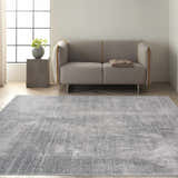 Modern living room with a grey sofa and the Calvin Klein CK970 Vapor Grey Ivory Area Rug on light wood floors.