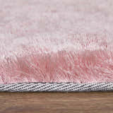 Close-up of the textured Feizy Indochine blush pink area rug, showing the soft pile and woven backing. Pile
