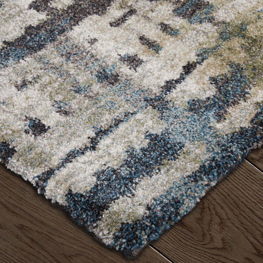 Close up of the Feizy Skyview rug; abstract gray, black, and ivory pattern on a soft, textured pile. Corner