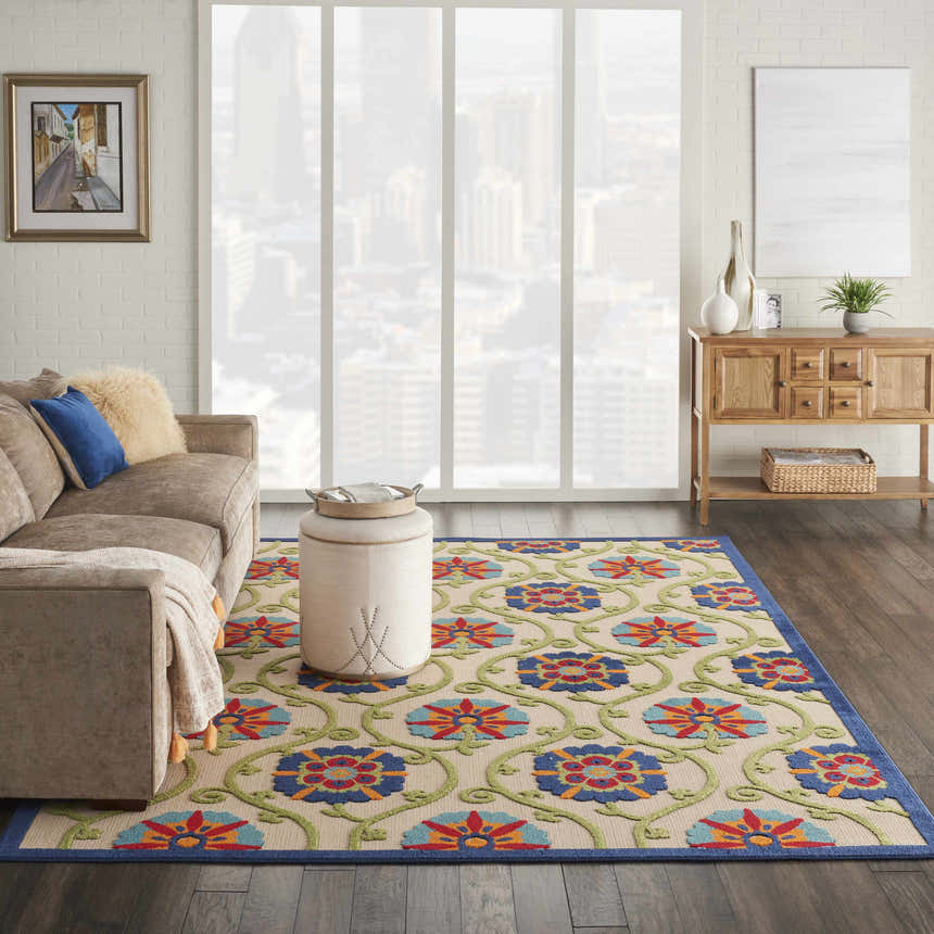 Living room scene with Nourison Aloha Blue Multicolor rug, sofa, ottoman, and wood console table.