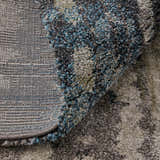 Close-up of Feizy Skyview rug showing gray, black, ivory, and blue abstract pattern and texture. Machine-made weave detail. Fold