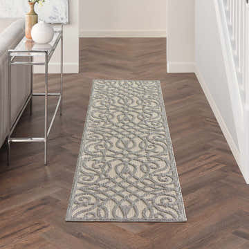 Hallway scene with a Nourison Cozumel Cream Grey Farmhouse Area Rug runner on dark wood floors. Console table on the left.