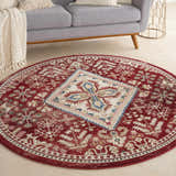 Living room scene with a round Nourison Karisma Brick Ivory rug, gray sofa, and light wood floors. Farmhouse style.