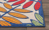 Close-up of Nourison Aloha Multicolor Tropical Area Rug featuring orange, red and green leaves with blue trim.