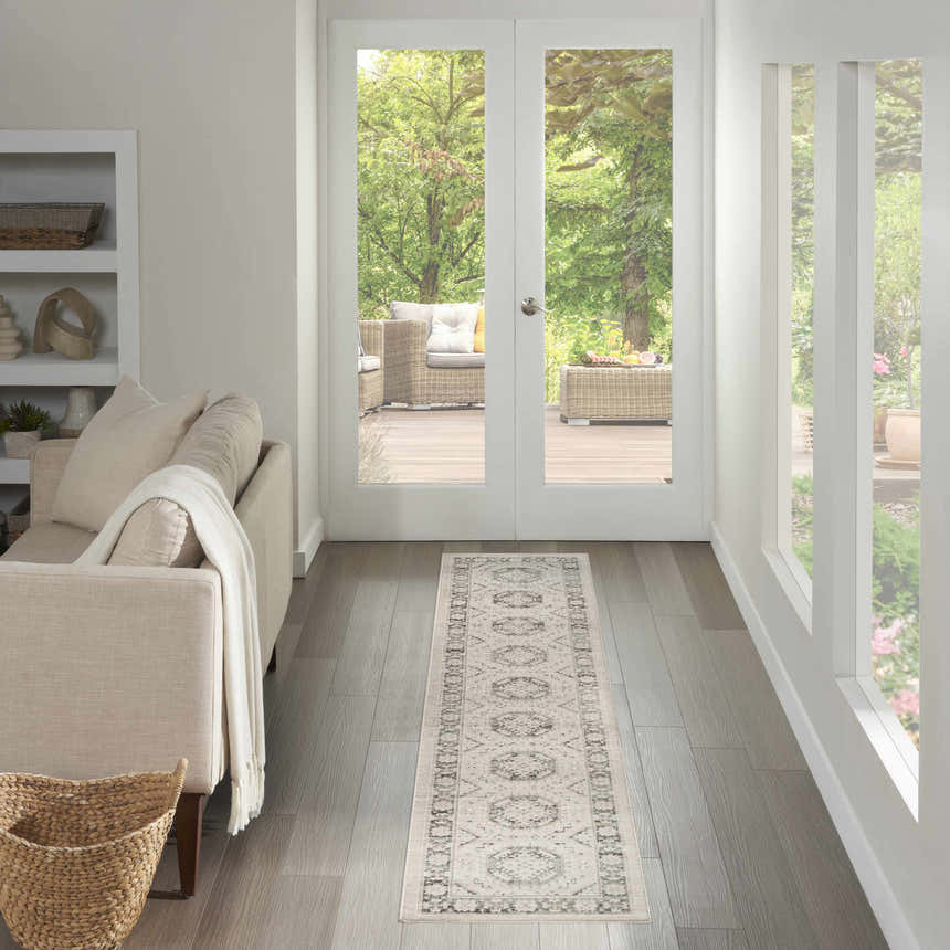 Hallway with Nourison Serenity Home Ivory Grey vintage runner rug, light wood floors, white walls, and outdoor patio view.
