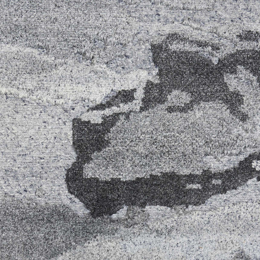 Close-up of the Nourison Divine Smoke Rug showing its gray tones, textured weave, and abstract pattern.