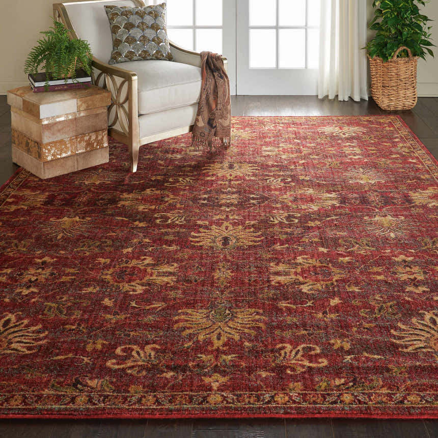 Living room scene with a brick red Nourison Jewel Brick Persian rug, cream chair, and dark wood floors.