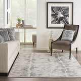 Living room scene with a Nourison OCEAN Cream Charcoal rug, sofa, chair, and modern decor.