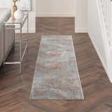 Hallway with Nourison Rustic Textures Light Grey Rust rug, wood floors, console table, and neutral decor.