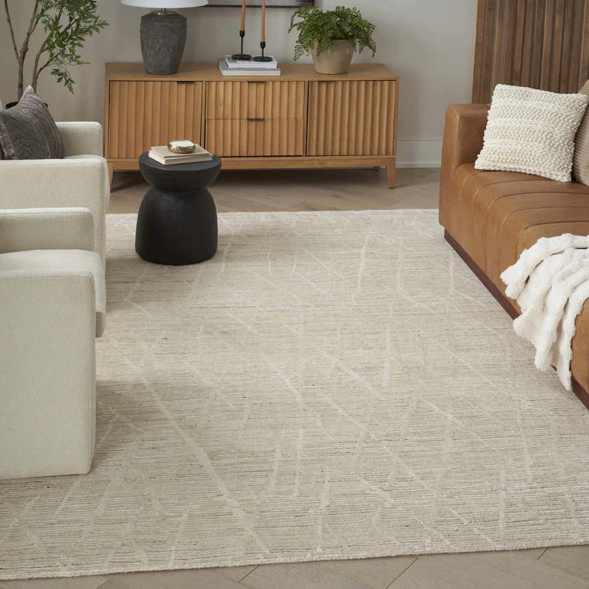 Living room with a Nourison OCEAN Pearl rug, cream sofa, tan leather couch, and wood cabinet.