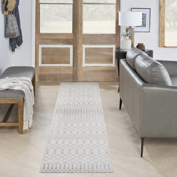 Entryway with gray leather sofa and Nourison Astra Ivory Bohemian rug runner on light wood floors.