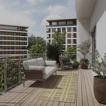 Modern balcony scene with a green Nourison Horizon Indoor/Outdoor Area Rug, sofa, chair, and potted plants.