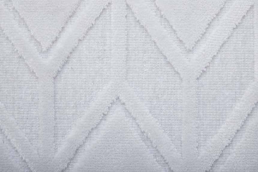 Close-up of the Feizy Saphir Mira white rug, showcasing its geometric criss-cross swirls pattern and soft, textured cotton blend. Texture