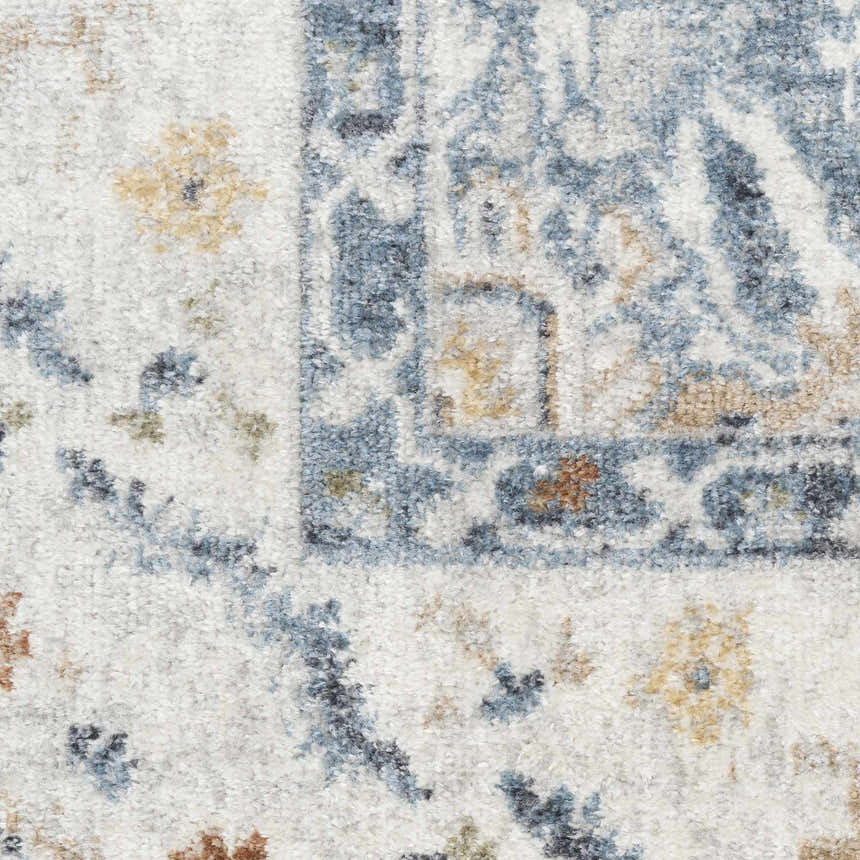 Close-up of the Nourison Astra Blue Vintage Rug showing its light blue, gold, and brown vintage-style pattern and soft texture.