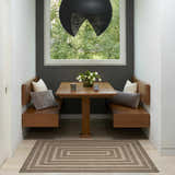 Breakfast nook with wood benches and Tulum Brown Outdoor Area Rug.