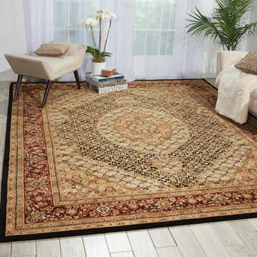 Living room scene with a Nourison 2000 Black Persian rug, cream chairs, white curtains, and light wood floors.