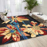 Bright living room with Nourison South Beach Black Area Rug featuring large floral pattern in red, yellow, and blue.