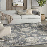 Living room scene with a blue beige vintage Nourison Quarry area rug, gray sofa, and neutral decor.