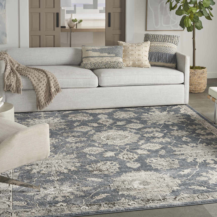 Living room scene with a blue beige vintage Nourison Quarry area rug, gray sofa, and neutral decor.