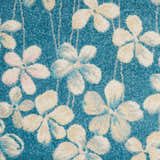 Close-up of the Nourison Tranquil Turquoise rug with a floral pattern in cream, beige, and blue hues.