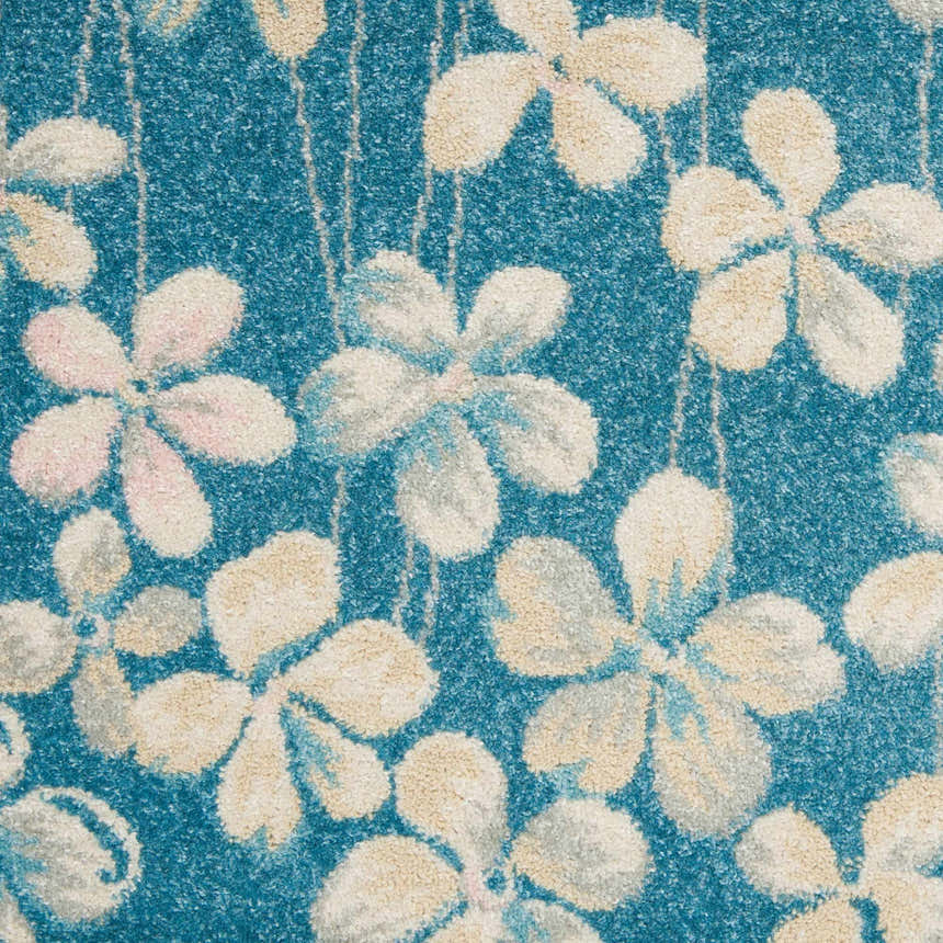 Close-up of the Nourison Tranquil Turquoise rug with a floral pattern in cream, beige, and blue hues.