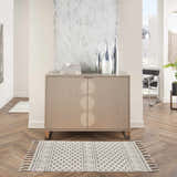 Modern hallway with Nourison Paxton Ivory/Grey rug, wood floors, and stylish cabinet with silver vases.